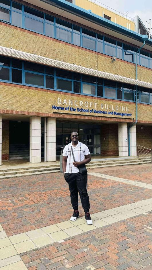 Student posing in front of a building