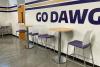high top table and chairs against wall with GO DAWG decor